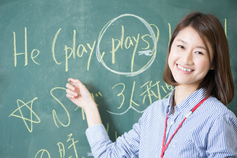 黒板を使って英語を教えている女性教員